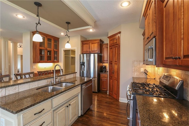 16488 S Summertree Ln, Olathe, KS 66062 - kitchen featuring appliances with stainless steel finishes, glass insert cabinets, backsplash, dark stone counters, and hanging light fixtures