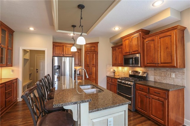 16488 S Summertree Ln, Olathe, KS 66062 - kitchen featuring appliances with stainless steel finishes, a kitchen bar, dark wood-type flooring, glass insert cabinets, and tasteful backsplash