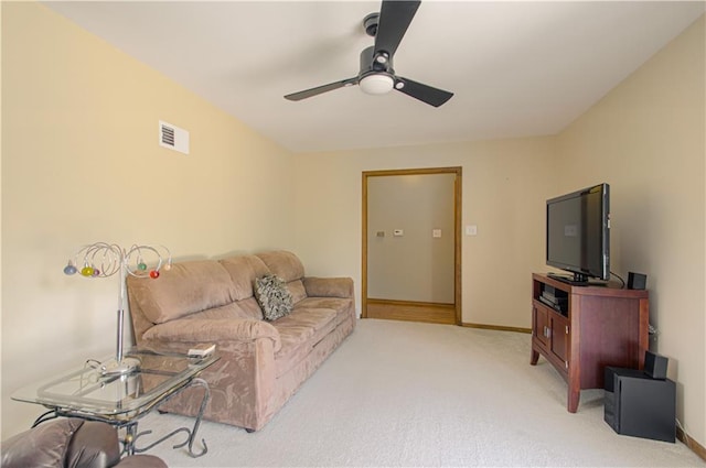 5037 Spring Ave, Kansas City, MO 64133 - living area featuring a ceiling fan, light carpet, and baseboards