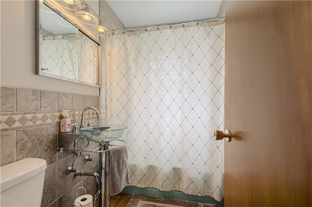 5037 Spring Ave, Kansas City, MO 64133 - full bath with tile walls, toilet, a sink, and a shower with curtain