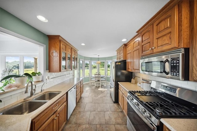 2640 Union Rd, Lawrence, KS 66044 - kitchen featuring stainless steel appliances, decorative backsplash, brown cabinetry, recessed lighting, and glass insert cabinets