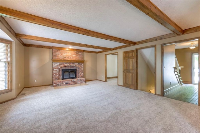 324 N Persimmon Dr, Olathe, KS 66061 - unfurnished living room featuring light colored carpet, beam ceiling, a textured ceiling, a fireplace, and stairs