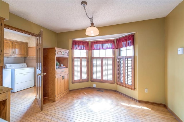 324 N Persimmon Dr, Olathe, KS 66061 - unfurnished room featuring light wood-type flooring, separate washer and dryer, and a textured ceiling