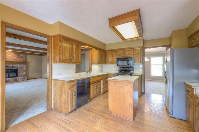 324 N Persimmon Dr, Olathe, KS 66061 - kitchen featuring black appliances, a kitchen island, light countertops, and light wood finished floors