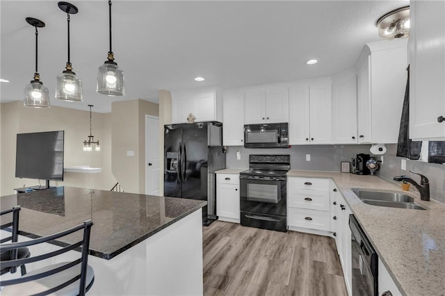 2604 S 16th Ter, Leavenworth, KS 66048 - kitchen with black appliances, a sink, white cabinets, hanging light fixtures, and recessed lighting