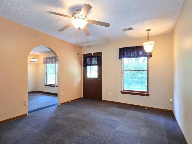 2101 Hillview Rd, Liberty, MO 64068 - entrance foyer featuring arched walkways, a textured ceiling, a ceiling fan, and dark carpet