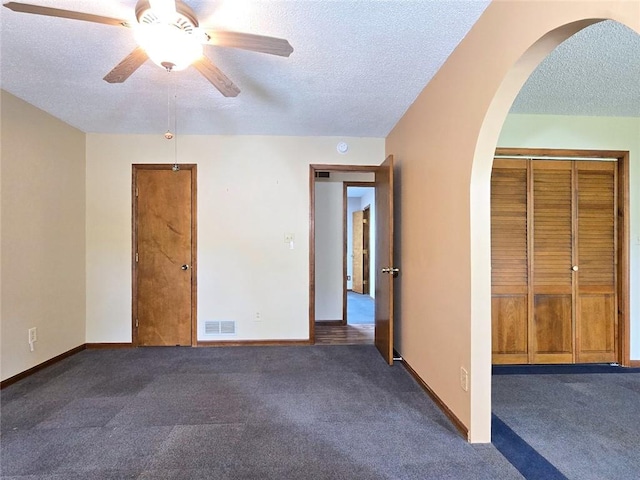 2101 Hillview Rd, Liberty, MO 64068 - spare room with a textured ceiling, arched walkways, dark carpet, and a ceiling fan