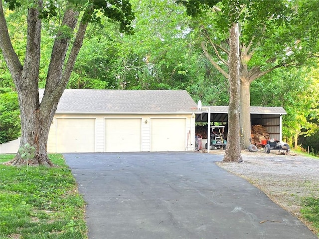 2101 Hillview Rd, Liberty, MO 64068 - view of front of home featuring a garage, an outbuilding, and roof with shingles
