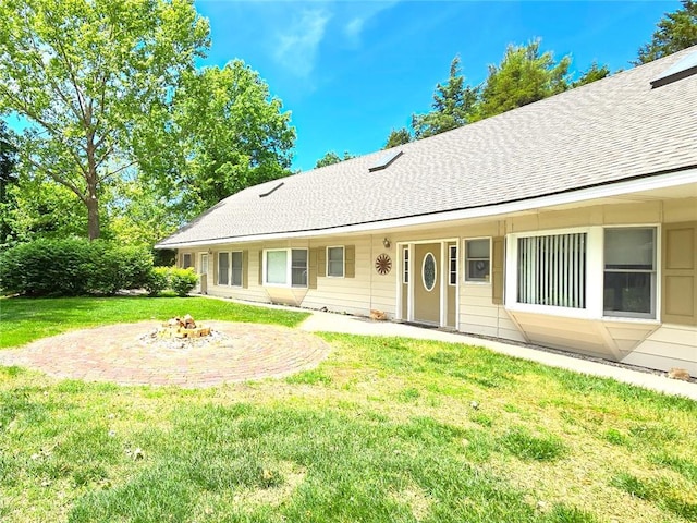 2101 Hillview Rd, Liberty, MO 64068 - back of property with an outdoor fire pit, a lawn, and a shingled roof