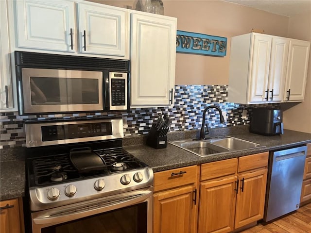 32592 SE 500th Rd, Kincaid, KS 66039 - kitchen with stainless steel appliances, backsplash, dark countertops, white cabinetry, and light wood finished floors
