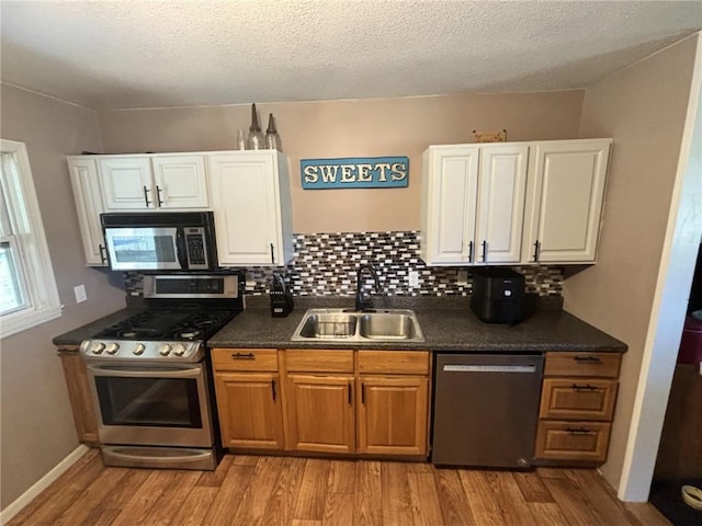 32592 SE 500th Rd, Kincaid, KS 66039 - kitchen with stainless steel appliances, light wood finished floors, dark countertops, white cabinets, and a textured ceiling