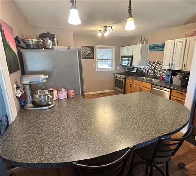 32592 SE 500th Rd, Kincaid, KS 66039 - kitchen featuring appliances with stainless steel finishes, a breakfast bar area, dark countertops, and a peninsula