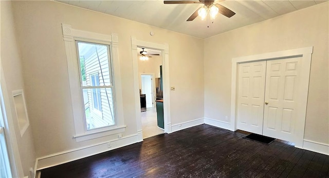 524 S Hill St, Fort Scott, KS 66701 - unfurnished bedroom with multiple windows, dark wood-type flooring, baseboards, and ceiling fan