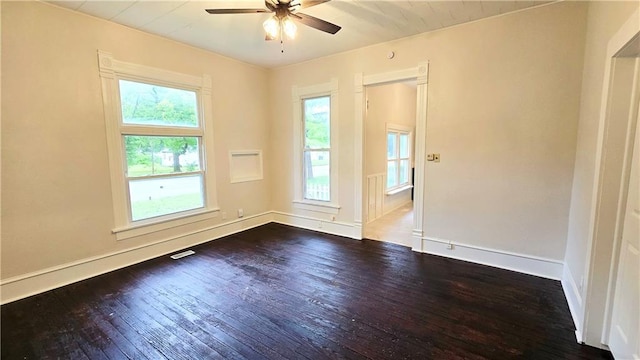 524 S Hill St, Fort Scott, KS 66701 - unfurnished room with dark wood-type flooring, plenty of natural light, a ceiling fan, and baseboards