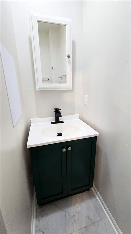 524 S Hill St, Fort Scott, KS 66701 - bathroom with marble look tile flooring, vanity, and baseboards
