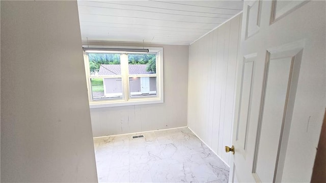 524 S Hill St, Fort Scott, KS 66701 - spare room with baseboards, marble finish floors, and wood walls