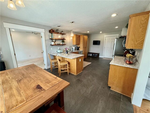 226 James Ave, Maryville, MO 64468 - kitchen featuring a sink, a peninsula, a textured ceiling, recessed lighting, and baseboards