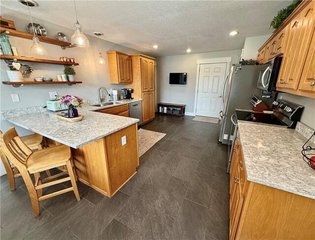 226 James Ave, Maryville, MO 64468 - kitchen with appliances with stainless steel finishes, a sink, a textured ceiling, a peninsula, and recessed lighting
