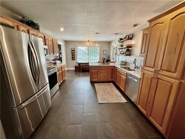 226 James Ave, Maryville, MO 64468 - kitchen with stainless steel appliances, a peninsula, a sink, light countertops, and a textured ceiling