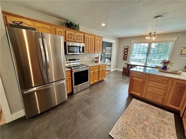 226 James Ave, Maryville, MO 64468 - kitchen with stainless steel appliances, light countertops, a chandelier, baseboards, and a textured ceiling