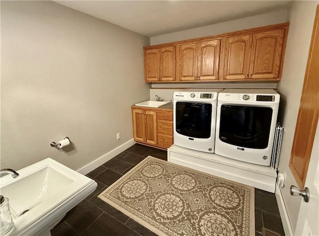 226 James Ave, Maryville, MO 64468 - laundry area featuring independent washer and dryer, cabinet space, baseboards, and dark tile patterned flooring