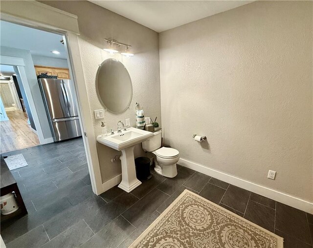 226 James Ave, Maryville, MO 64468 - bathroom with baseboards, toilet, and a textured wall