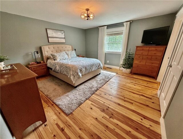226 James Ave, Maryville, MO 64468 - bedroom featuring light wood-style floors, a chandelier, and baseboards