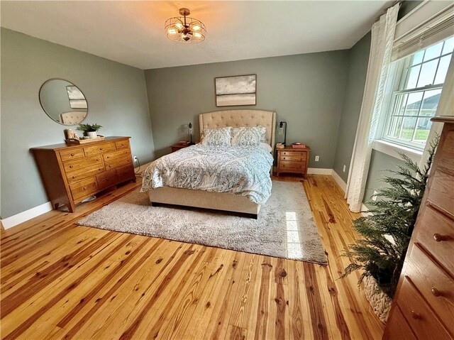 226 James Ave, Maryville, MO 64468 - bedroom with wood finished floors, baseboards, and a chandelier