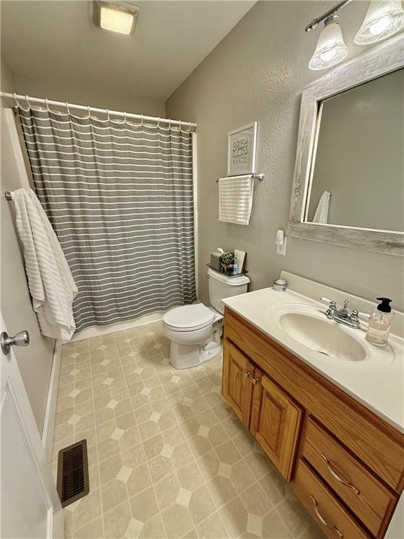 226 James Ave, Maryville, MO 64468 - bathroom featuring vanity, toilet, and a shower with curtain