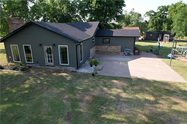 4004 Texaco Rd, Cushing, OK 74023 - back of property with a patio, a yard, a chimney, roof with shingles, and a playground