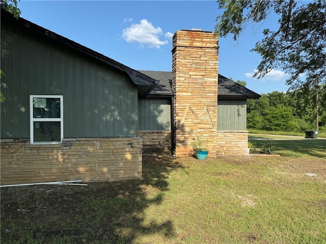 4004 Texaco Rd, Cushing, OK 74023 - view of side of home with a lawn, a chimney, a shingled roof, and stone siding