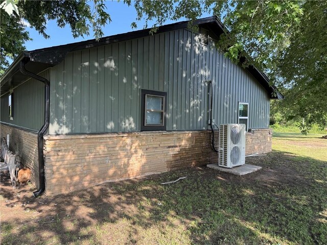 4004 Texaco Rd, Cushing, OK 74023 - view of side of home featuring board and batten siding, ac unit, and brick siding