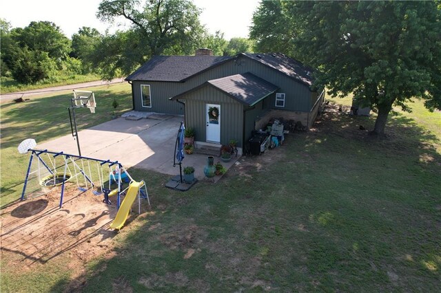4004 Texaco Rd, Cushing, OK 74023 - back of property featuring a chimney, a yard, a playground, a patio area, and a shingled roof