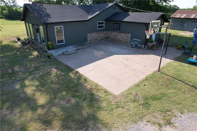 4004 Texaco Rd, Cushing, OK 74023 - rear view of house with a shingled roof, a lawn, a patio, and a chimney
