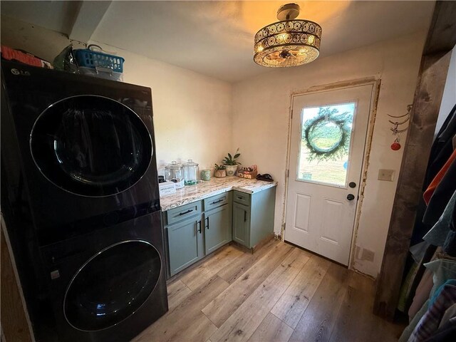 4004 Texaco Rd, Cushing, OK 74023 - laundry room with stacked washer / drying machine, cabinet space, and light wood-style floors