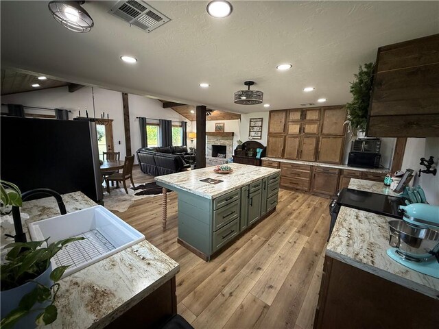 4004 Texaco Rd, Cushing, OK 74023 - kitchen with a sink, light wood-type flooring, black range with electric stovetop, recessed lighting, and a fireplace