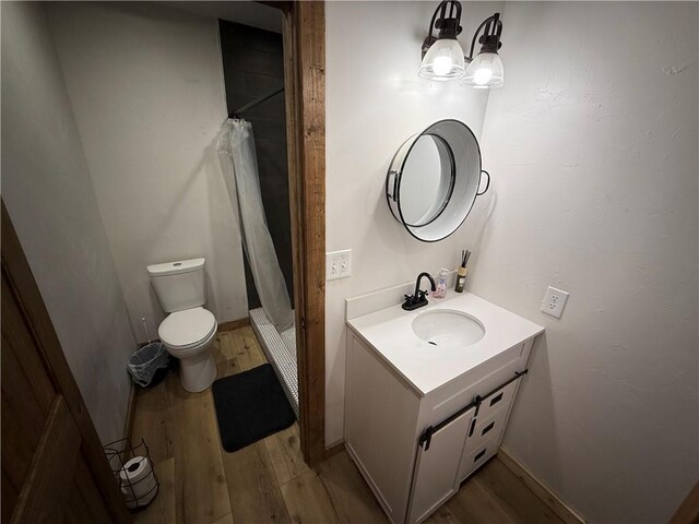 4004 Texaco Rd, Cushing, OK 74023 - full bathroom with wood finished floors, vanity, toilet, a shower stall, and a chandelier