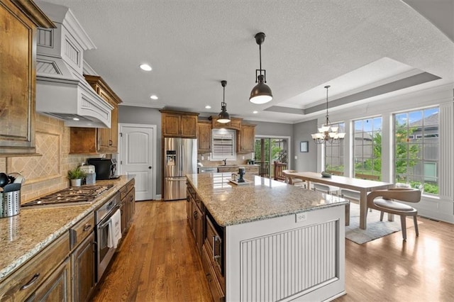 17208 W 198th St, Spring Hill, KS 66083 - kitchen featuring stainless steel appliances, wood finished floors, ornamental molding, brown cabinetry, and decorative backsplash