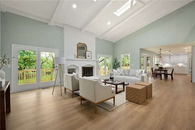 10775 Larsen St, Overland Park, KS 66210 - living area with high vaulted ceiling, beam ceiling, light wood-style flooring, a fireplace, and a skylight