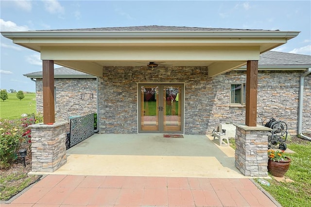 5260 SE Fox Run Rd, Lathrop, MO 64465 - property entrance featuring french doors, stone siding, a ceiling fan, a shingled roof, and a patio