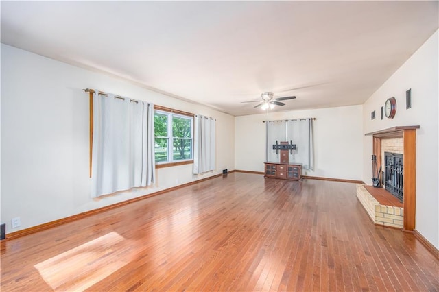3931 Main St, Parsons, KS 67357 - unfurnished living room featuring hardwood / wood-style floors, a fireplace, ceiling fan, and baseboards