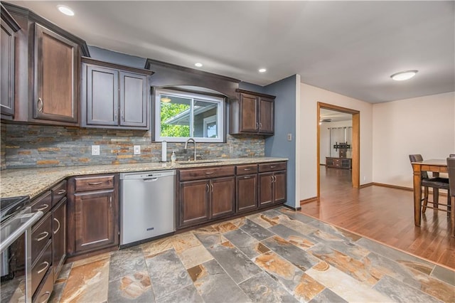 3931 Main St, Parsons, KS 67357 - kitchen featuring appliances with stainless steel finishes, a sink, tasteful backsplash, dark brown cabinets, and light stone counters