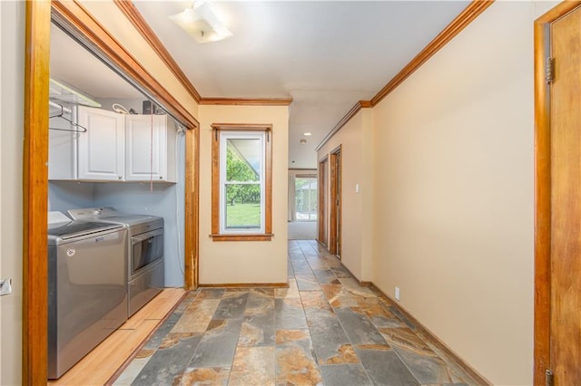 3931 Main St, Parsons, KS 67357 - laundry room featuring cabinet space, washer and clothes dryer, stone tile floors, ornamental molding, and baseboards