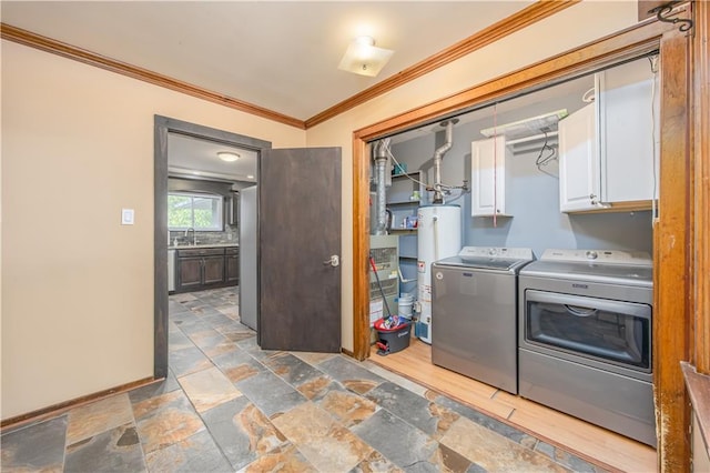 3931 Main St, Parsons, KS 67357 - laundry area with cabinet space, washer and clothes dryer, crown molding, gas water heater, and stone tile floors