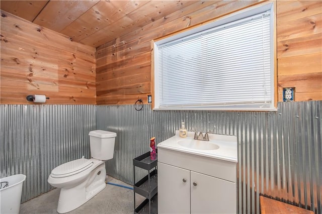 3931 Main St, Parsons, KS 67357 - half bathroom with toilet, vanity, concrete floors, and wooden walls