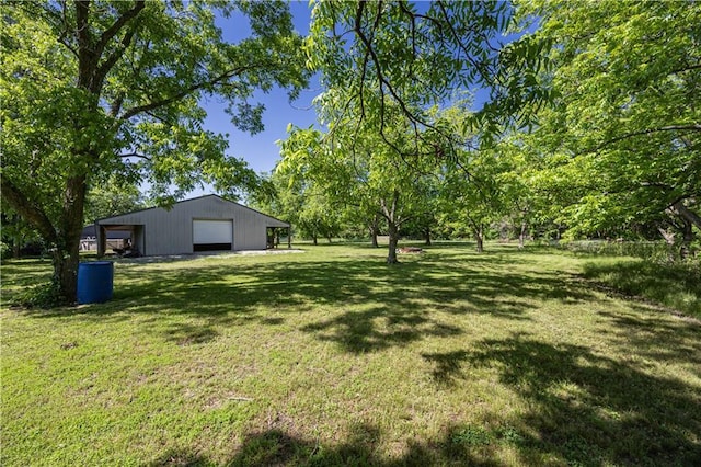 3931 Main St, Parsons, KS 67357 - view of green lawn featuring a detached garage and an outbuilding