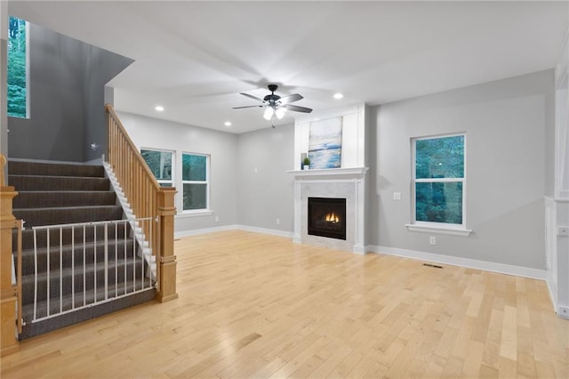 13807 W 47th Ter, Shawnee, KS 66216 - unfurnished living room featuring ceiling fan, stairs, light wood-style flooring, a large fireplace, and baseboards