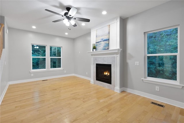 13807 W 47th Ter, Shawnee, KS 66216 - unfurnished living room featuring a ceiling fan, light wood-style floors, plenty of natural light, a glass covered fireplace, and recessed lighting