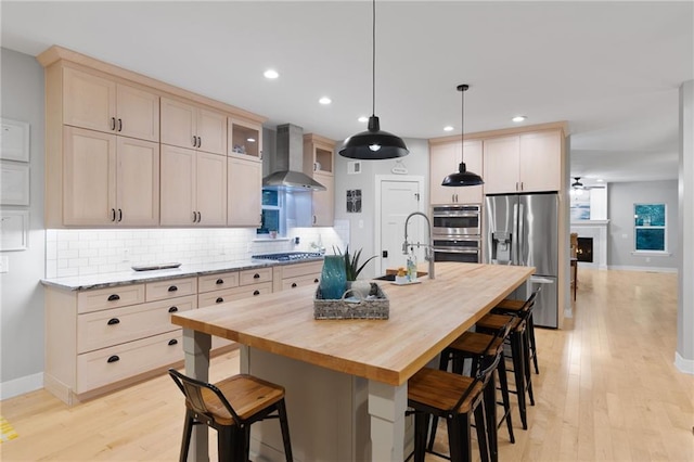 13807 W 47th Ter, Shawnee, KS 66216 - kitchen with stainless steel appliances, wall chimney exhaust hood, backsplash, light wood-type flooring, and baseboards
