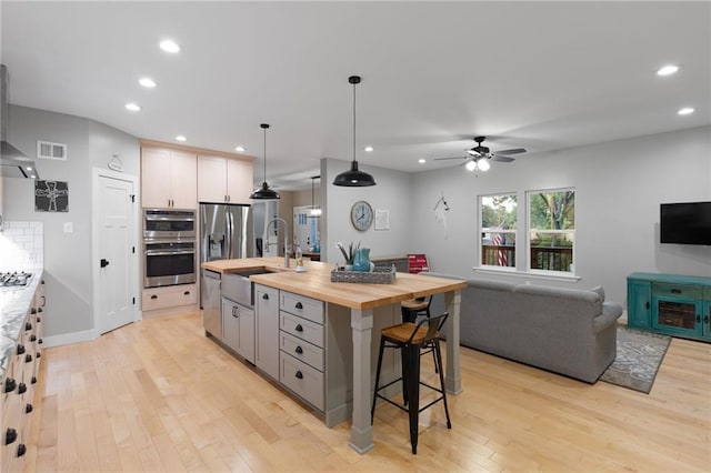 13807 W 47th Ter, Shawnee, KS 66216 - kitchen with wood counters, a sink, appliances with stainless steel finishes, a ceiling fan, and light wood-style floors
